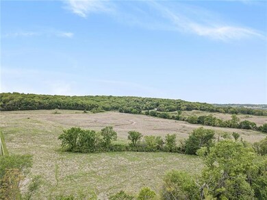 Level lot, treed and vast prairies with a creek