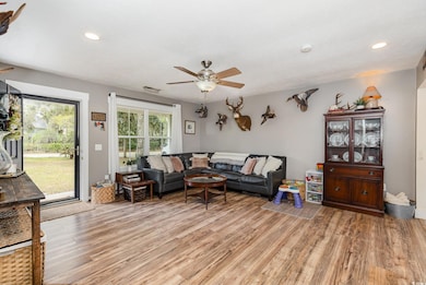 Living area featuring a ceiling fan, visible vents