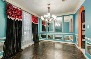 Dining room features elegant dark wood flooring, t