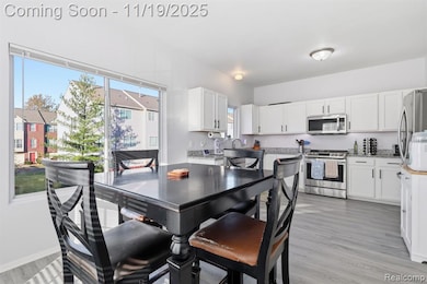 Dining room with healthy amount of natural light and light wood-style floors