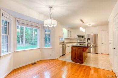 Spacious eat-in Nook with new lighting, hardwood floors and wood plantation blinds.