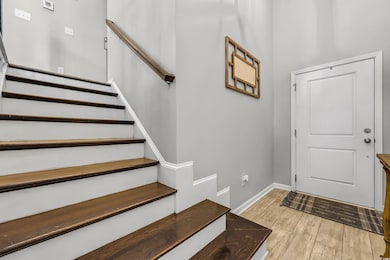 Foyer featuring stairs and light wood-style floors