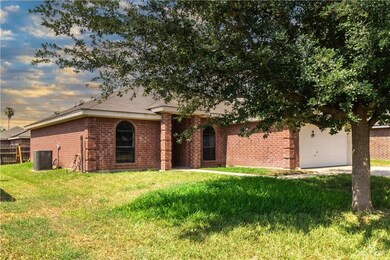 View of front of house with a lawn, central AC, and a garage