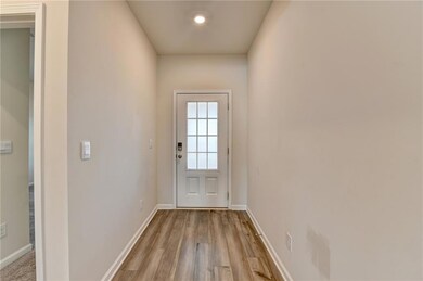 Doorway to outside featuring baseboards and light 