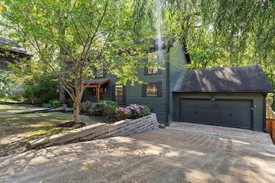View of front of house featuring concrete driveway, an attached garage, and a shingled roof