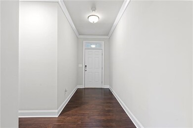 Doorway to outside with crown molding and dark wood-type flooring