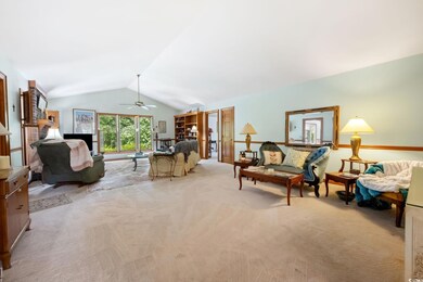 Carpeted living room featuring lofted ceiling and 