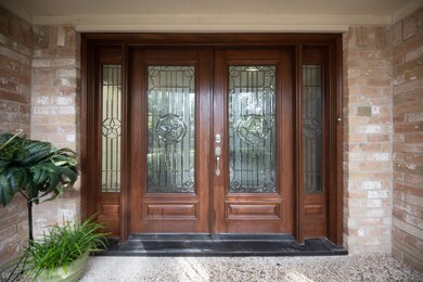 Solid double wood stained doors with leaded glass.