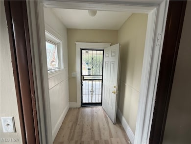 Doorway to outside with wood finished floors and baseboards