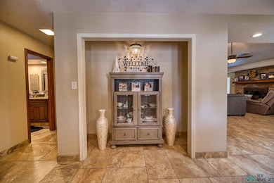 Interior space with a fireplace, a textured ceiling, ceiling fan, a chandelier, and recessed lighting