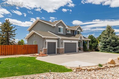 View of front of property with stucco siding, a garage, driveway, stone siding, and roof with shingles