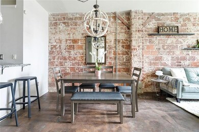 Dining space with brick wall, concrete floors, baseboards, and a chandelier