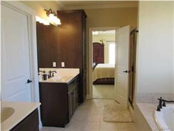The master bath has a double vanity and garden tub