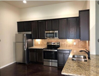 Kitchen featuring stainless steel appliances, tasteful backsplash, light stone countertops, and recessed lighting