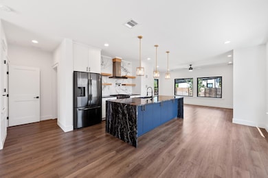 Kitchen with open shelves, stainless steel fridge