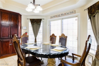 Dining space with a notable chandelier, light tile