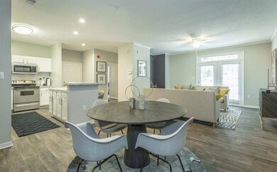 Dining area featuring a ceiling fan, dark wood-style floors, ornamental molding, and a textured ceiling