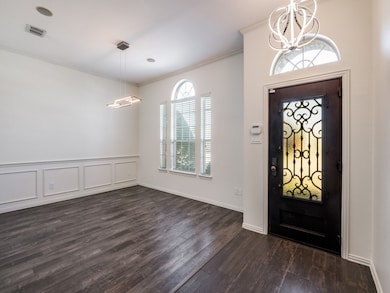 Entrance foyer with ornamental molding with pretty engineered wood floors