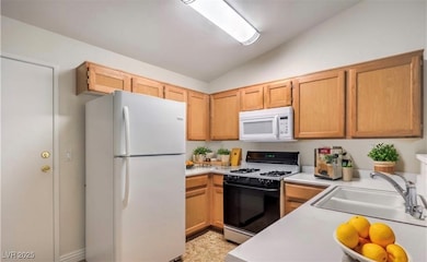 Kitchen with white appliances, light countertops,