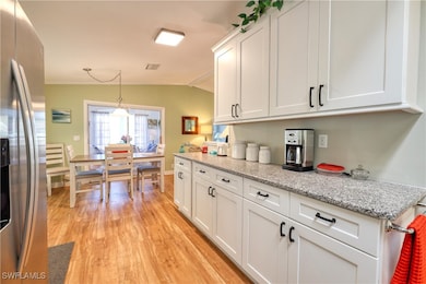 Kitchen with stainless steel fridge, light wood-ty