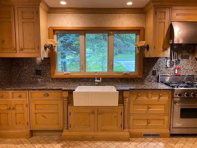 Kitchen with luxury range, ventilation hood, plenty of natural light, backsplash, and recessed lighting