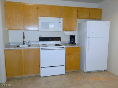 Kitchen with white appliances, light countertops,