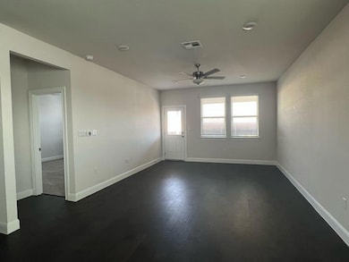 Unfurnished room featuring a ceiling fan, dark wo
