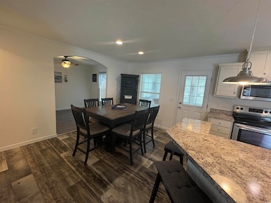 Dining space with ornamental molding, dark wood-st