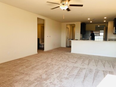 Unfurnished living room featuring a ceiling fan, 