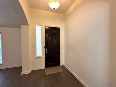 Entrance foyer with baseboards and arched walkways
