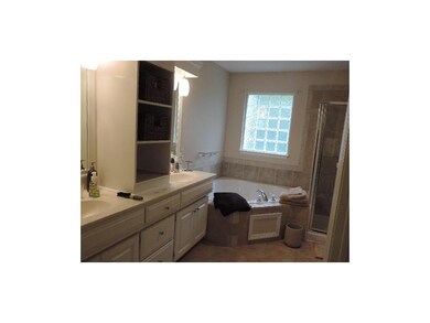 Master bath with dual sinks, tile floors and corne