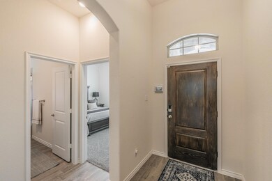 Foyer with light wood-type flooring and a high cei