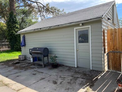 Back of house featuring roof with shingles and a patio