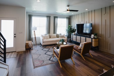 Living room featuring recessed lighting, dark wood-type flooring, and ceiling fan