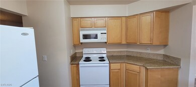 Kitchen featuring white appliances and light brown