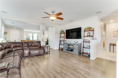 Living area with light wood finished floors, ceiling fan, and recessed lighting