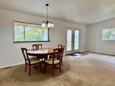 Dining area featuring carpet and a chandelier