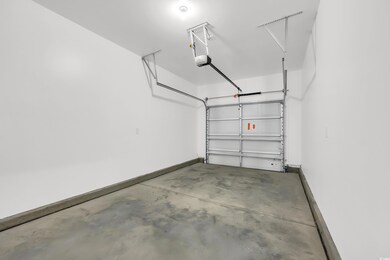Garage featuring baseboards and a garage door opener