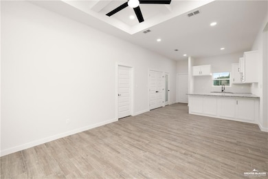 Unfurnished living room with light wood-type flooring, recessed lighting, and a ceiling fan
