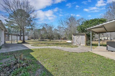 Back porch, main home water well shed and garage to the left