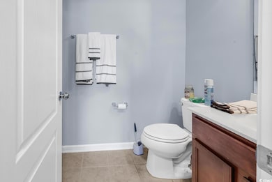 Bathroom with toilet, vanity, and tile patterned f