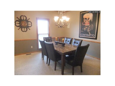 The formal dining room features neutral carpet, ch