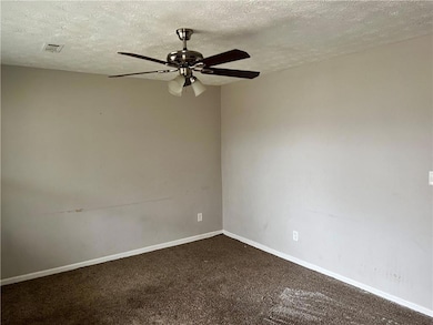 Spare room with ceiling fan, carpet, and a texture