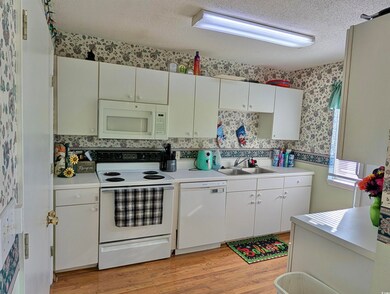 Kitchen featuring sink, white cabinets, white appl