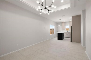 Kitchen with sink, a center island, stainless steel fridge, decorative light fixtures, and a chandelier