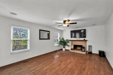 Family room with wood laminate flooring and brick 