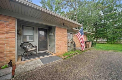 Property entrance featuring brick siding and a porch