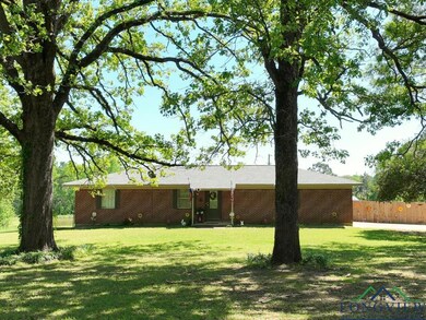 Ranch-style home with brick siding, fence, and a f