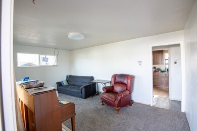 Carpeted living area featuring baseboards