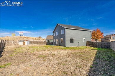 Rear view of house with a storage unit and a fenced backyard
